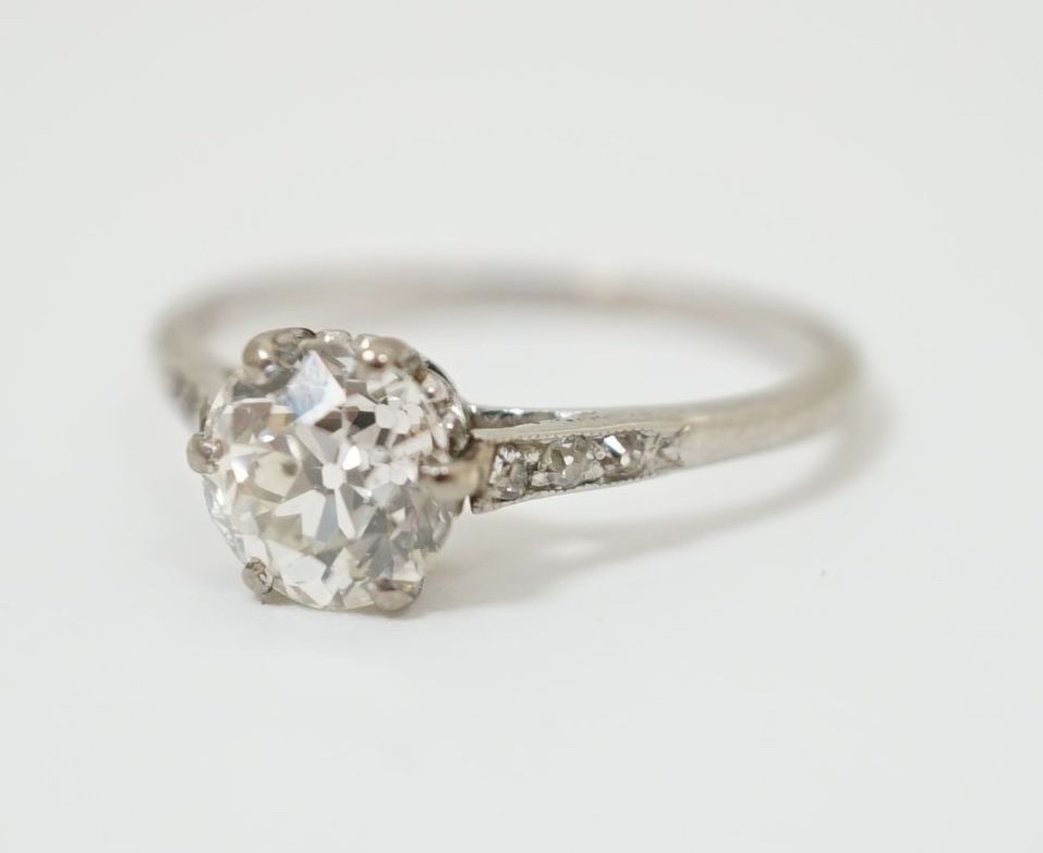 A platinum and single stone diamond ring, with diamond chip set shoulders